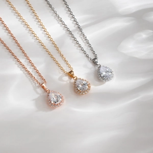 Vue macro de colliers en goutte d'eau en finitions rose doré, doré et argenté avec zircon