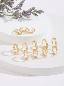 Detailed view of 10-piece gold ring set with heart and star patterns on white steps