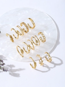 Flat lay of vintage gold jewelry set featuring feather and heart designs on white tray