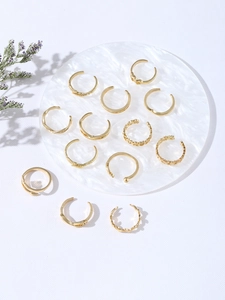 Set of 12 vintage gold metal rings featuring heart and star patterns on marble
