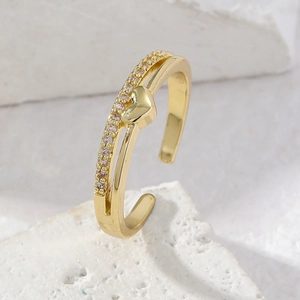 Detail eines verstellbaren Goldrings mit rosa Zirkonia und poliertem Herz-Anhänger