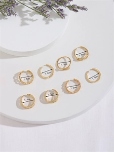 Detail view of 8-piece gold toe ring set with size labels 1.3cm to 1.5cm for stacking