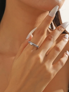 Detail eines silbernen Doppelrings mit funkelndem Zirkonia-Pavé und herzförmigem Anhänger