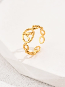 Macro di anello regolabile in oro con lettera A e fascia a catena su piedistallo di pietra