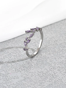Macro detail of silver leaf ring with purple marquise cut crystals and polished finish