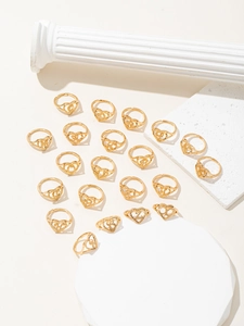 Dettaglio di anelli d'oro a forma di cuore con incisione di lettere e fascia regolabile