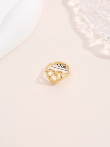 Dettaglio anello a cuore dorato con finitura testurizzata e fascia aperta da 1,7 cm