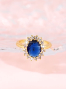 Macro detail of royal blue oval gemstone ring with a halo of sparkling white cubic zirconia