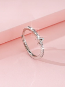 Dettaglio macro di un anello regolabile in argento con lettera A e zirconi scintillanti