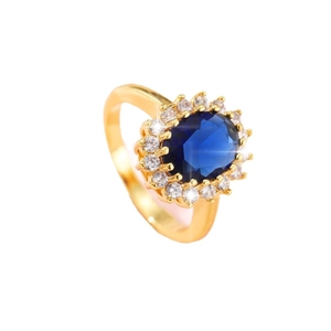 Luxurious gold-tone ring featuring a large oval blue sapphire stone with a zircon halo