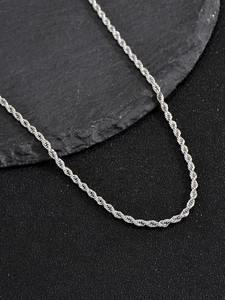Vue macro d'une chaîne corde de 3mm en acier inoxydable argenté sur fond de pierre
