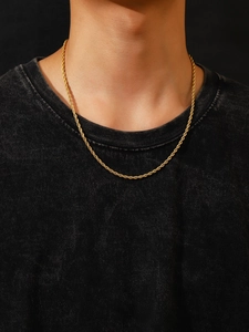 Vue rapprochée d'une chaîne corde dorée de 3mm en acier sur un t-shirt noir minimaliste