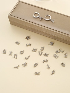 Détail de breloques lettres argentées avec strass et ensemble de créoles assorties