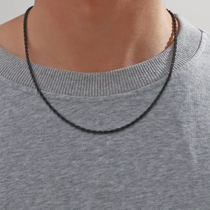 Gros plan détaillé d'une chaîne corde en acier inoxydable noir 3mm sur un pull gris