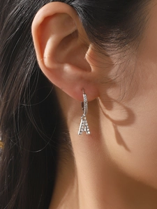 Gros plan d'une boucle d'oreille créole argentée lettre A ornée de zircons blancs brillants