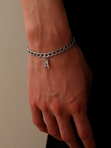 Detail van een zilveren roestvrijstalen Cubaanse kettingarmband met letter A hanger