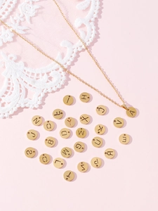 Détail macro de l'ensemble de pendentifs lettres A-Z dorés avec gravure évidée