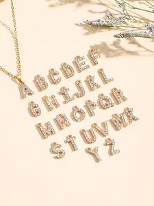 Detalle del collar con colgante letra A dorada y pavé de cristales blancos brillantes