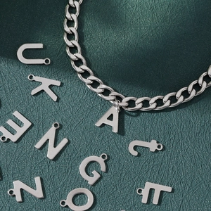 Gepolijste zilveren roestvrijstalen cubaanse schakelarmband met letterhangers