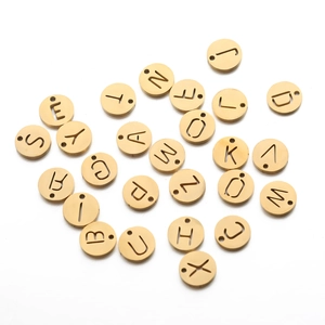 Gros plan détaillé de pendentifs circulaires dorés avec lettres de l'alphabet A-Z évidées