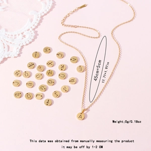 Collier avec pendentif lettre en acier inoxydable doré sur fond rose avec dentelle