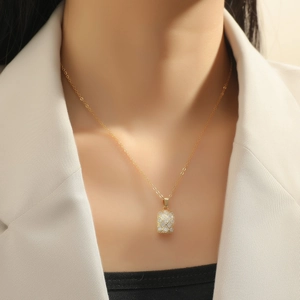 Close-up of a gold pineapple necklace with sparkling zircon crystals on a female model