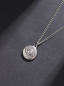 Detail shot of vintage silver Evil Eye pendant with matte finish on link chain
