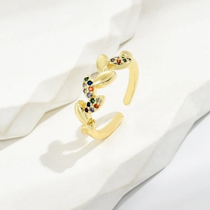 Elegant gold leaf open ring with multi-color zircon stones on white stone base