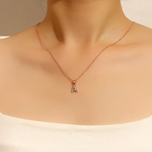 Primer plano del collar con colgante letra A en oro rosa y cristales brillantes