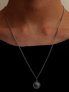 Close-up of a vintage Evil Eye pendant necklace on a stainless steel chain for women