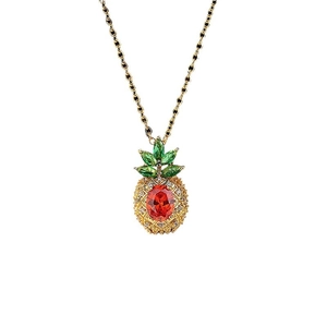 Chic gold pineapple pendant necklace with red crystals and green leaves on white background