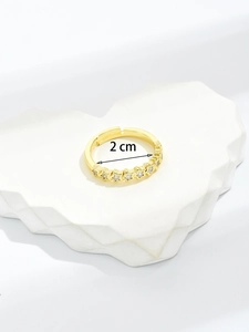 Detailed view of an adjustable gold star ring with micro-inlaid zircons and 2cm diameter