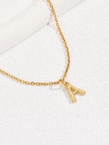 Close-up of golden alphabet A pendant necklace with elegant bamboo texture detail