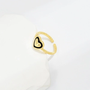 Adjustable golden heart ring with black enamel and spiral texture on a stone stand