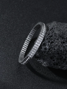 Macro view of silver elastic stainless steel bracelet with square links and inlaid crystals