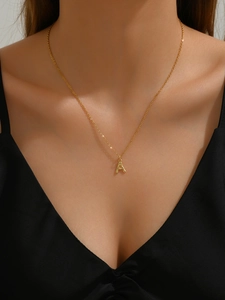 Close-up of a gold-plated bamboo-style capital letter A pendant necklace on a neck