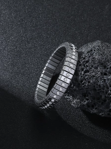 Detail of silver stretch bracelet with inset diamonds on a dark volcanic rock surface