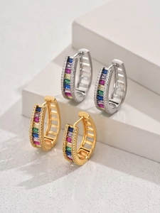 Détail de boucles d'oreilles en U dorées et argentées avec zircons arc-en-ciel colorés