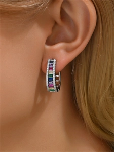 Gros plan de boucles d'oreilles en C avec pierres précieuses colorées et cristaux pavés