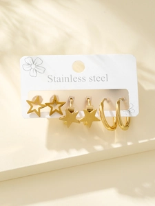 Détail d'un lot de trois boucles d'oreilles dorées en acier avec étoiles et anneaux