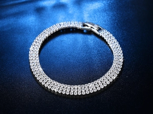 Makroansicht des dreireihigen Tennisarmbands mit Kristallen auf dunkelblauem Samt