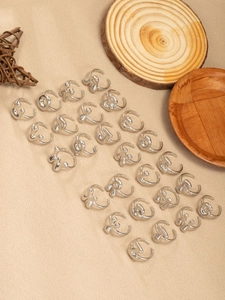 Selezione di anelli a bolle d'argento su legno naturale e sfondo beige strutturato