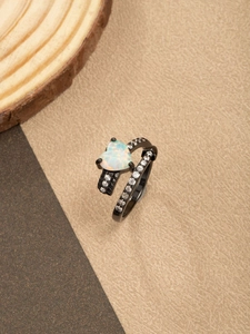 Detalle de anillo de opalo con forma de corazón, acabado negro y banda con pavé
