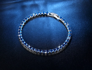 Detailansicht eines silbernen Tennisarmbands mit rund geschliffenen blauen Zirkonia-Steinen