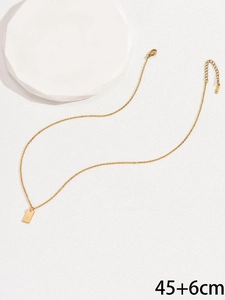 Dettaglio della collana in acciaio dorato con pendente quadrato lettera A e catena regolabile