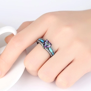 Anillo de corazón en oro negro moderno con opale y topacio en la mano de una modelo