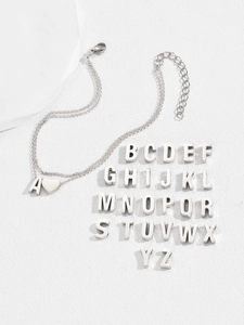 Flat lay of double-layered stainless steel heart anklet set with all 26 alphabet charms