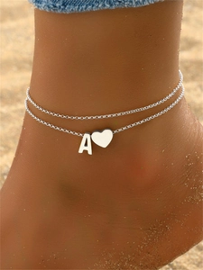 Double-layered stainless steel anklet with letter A and heart pendant on sandy beach