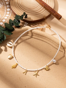 Vue détaillée du collier de perles océan avec pendentifs coquillage, étoile de mer et A