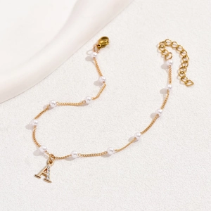 Bracelet de cheville en perles dorées avec lettre A et zircons pour femmes sur blanc